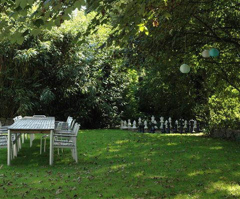 Groepshuis in Drenthe met ruime besloten en tuin en een schaakbord buiten.