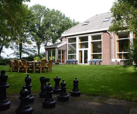 Groepsaccommodatie in Drenthe met ruime tuin met schaakbord.